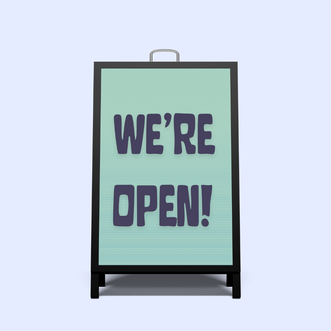 Black A-Frame sign with 'WE'RE OPEN!' text on a light green background