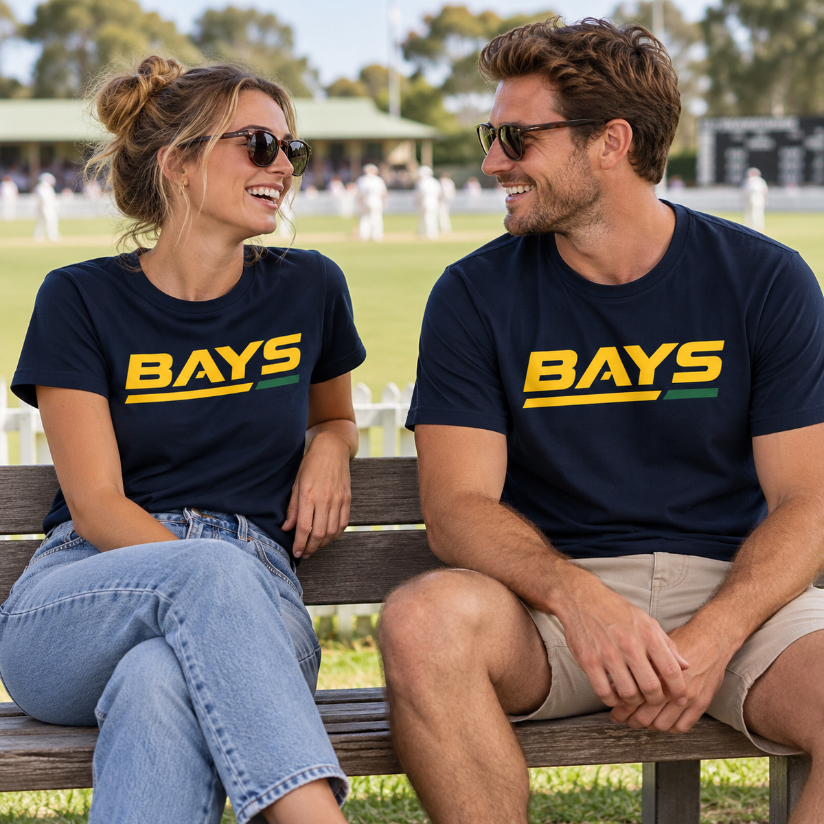 Couple wearing the navy BAYS T-shirt at the cricket