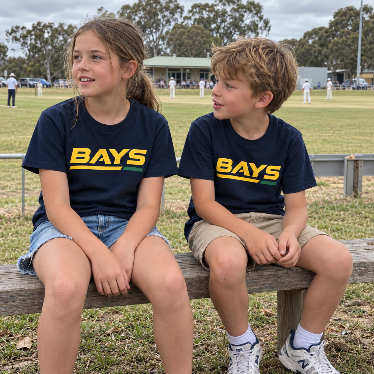 Kids wearing the navy BAYS T-shirt at the cricket